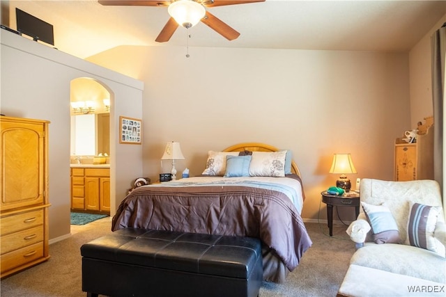 carpeted bedroom with a ceiling fan, arched walkways, vaulted ceiling, and ensuite bathroom