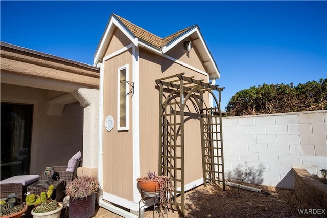 exterior space with a shingled roof and fence