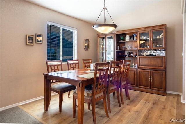 dining room featuring baseboards and light wood-style floors