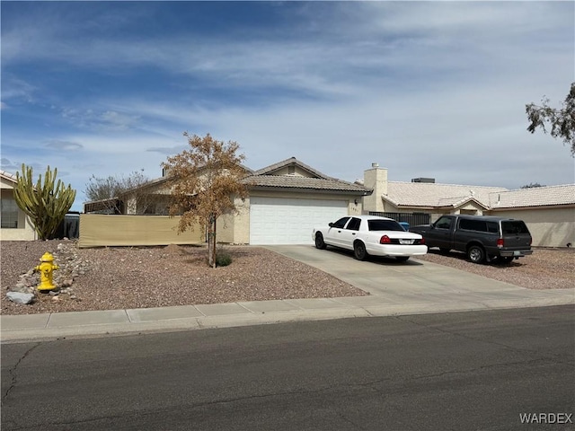 view of front of home with driveway, an attached garage, a tiled roof, and stucco siding