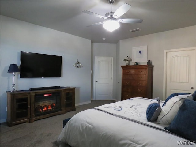 bedroom with carpet, a fireplace, visible vents, ceiling fan, and baseboards