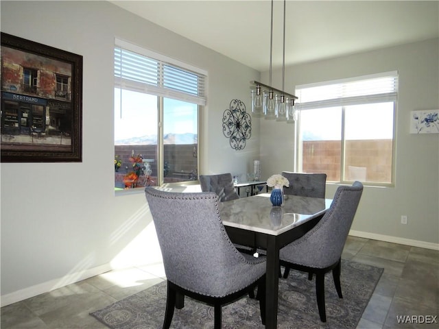 dining space with plenty of natural light, tile patterned floors, and baseboards