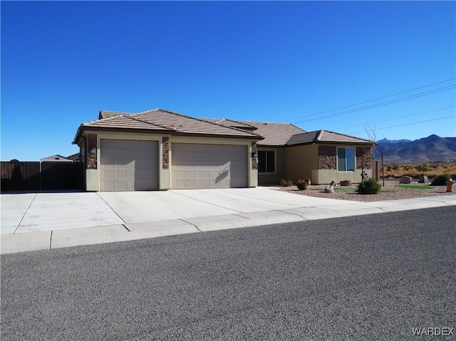 view of front of property with a garage, a tile roof, a mountain view, and stucco siding