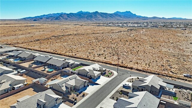 drone / aerial view featuring a residential view, view of desert, and a mountain view