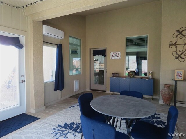 dining area featuring baseboards and a wall mounted air conditioner