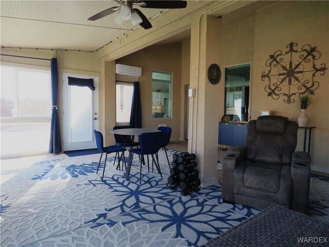 view of patio / terrace featuring a wall unit AC, ceiling fan, and outdoor dining area