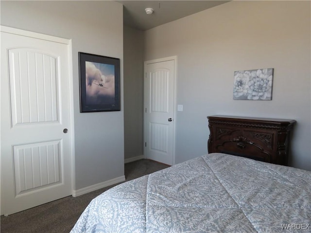 bedroom featuring baseboards and dark carpet