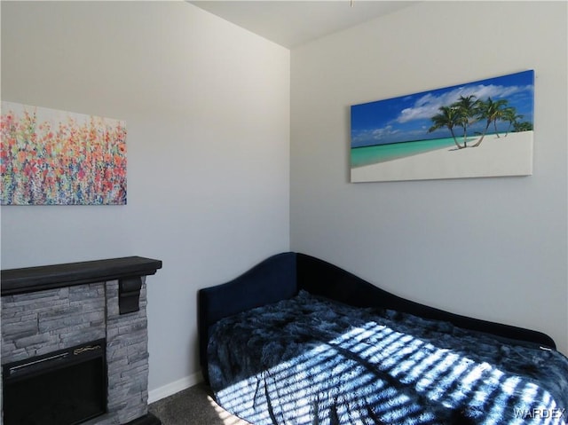 bedroom featuring a fireplace, carpet flooring, and baseboards