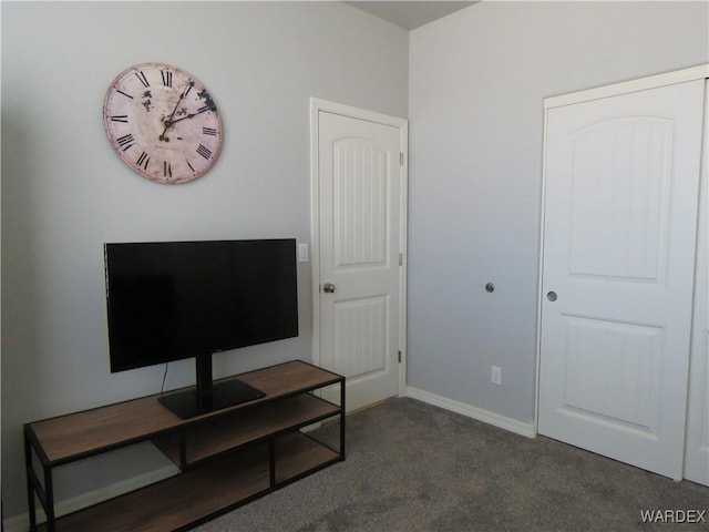 bedroom with dark carpet and baseboards