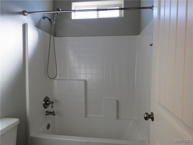 bathroom featuring washtub / shower combination and toilet