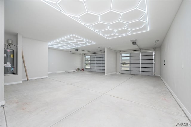 garage with a garage door opener, electric water heater, and baseboards