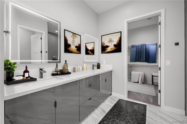 full bathroom featuring marble finish floor, baseboards, and vanity