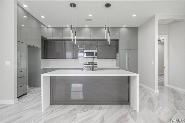 kitchen with light countertops, appliances with stainless steel finishes, modern cabinets, and gray cabinetry