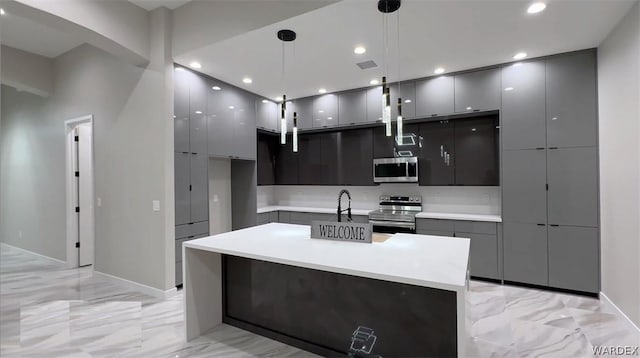 kitchen featuring stainless steel appliances, light countertops, hanging light fixtures, and modern cabinets