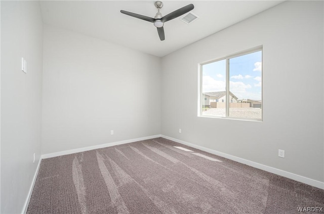 carpeted spare room with visible vents, ceiling fan, and baseboards