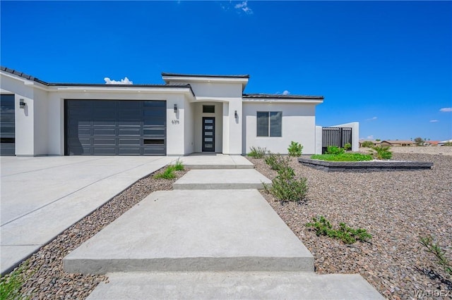 view of front of house featuring driveway, an attached garage, and stucco siding