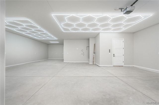 garage featuring a garage door opener and baseboards