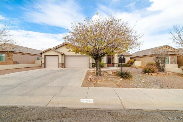 view of front of property with concrete driveway, an attached garage, and stucco siding