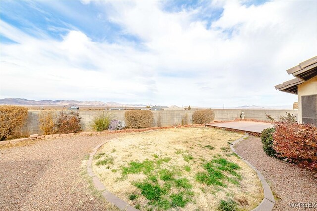 view of yard with a patio area, a fenced backyard, and a mountain view