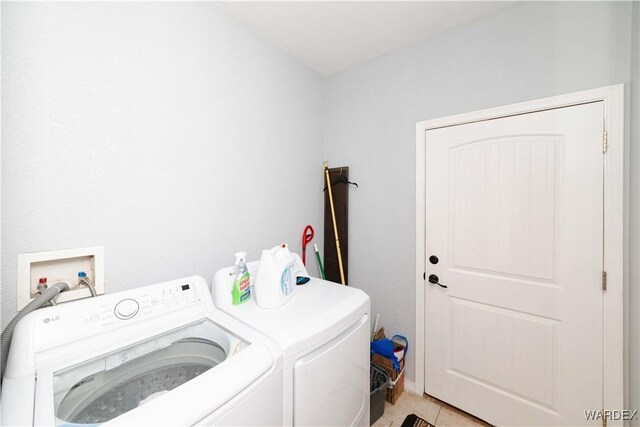 washroom featuring laundry area, light tile patterned flooring, and separate washer and dryer