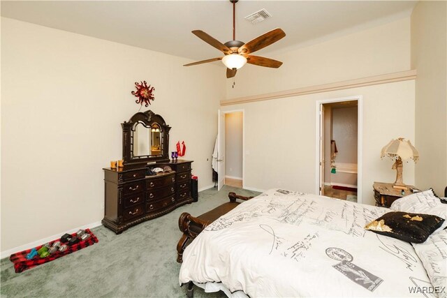 carpeted bedroom featuring a ceiling fan, connected bathroom, visible vents, and baseboards