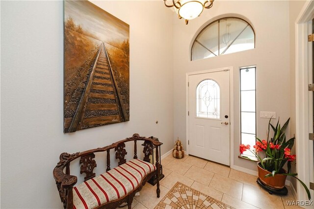 foyer entrance featuring baseboards and light tile patterned floors