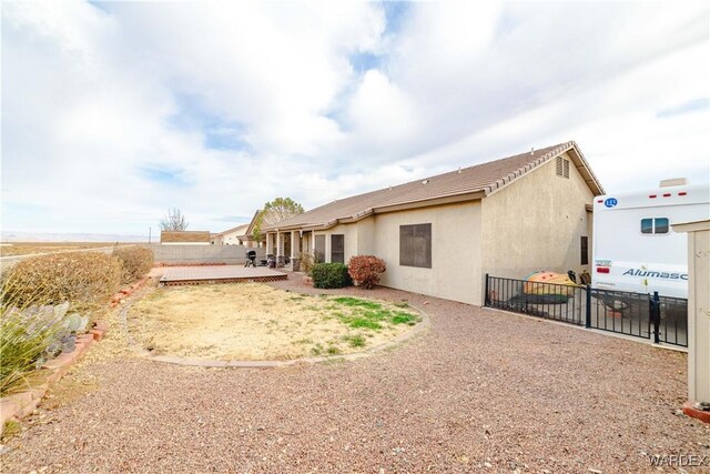 back of property featuring a patio area, fence, and stucco siding