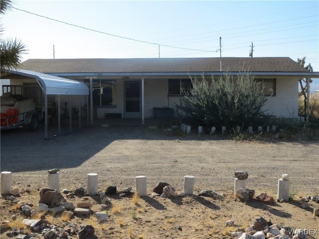 view of front of home featuring stucco siding and roof with shingles