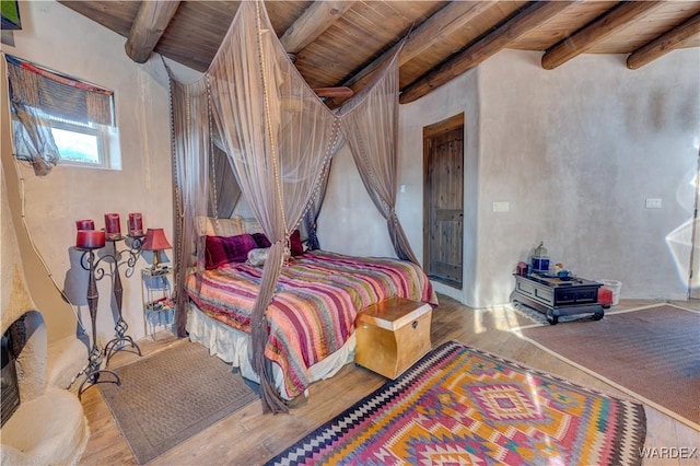 bedroom with beam ceiling, wood ceiling, and wood finished floors