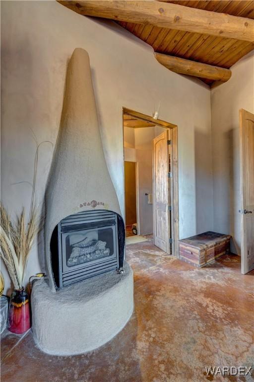 room details featuring heating unit, beamed ceiling, wooden ceiling, and a wood stove