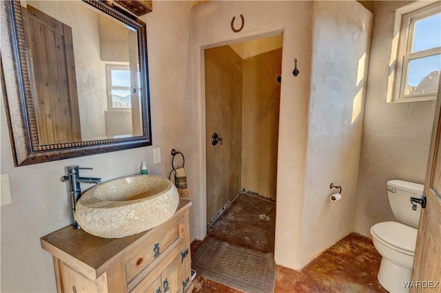 bathroom featuring vanity, toilet, and a healthy amount of sunlight