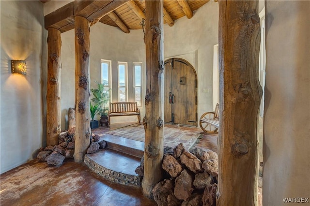 misc room with beamed ceiling, wooden ceiling, and a towering ceiling