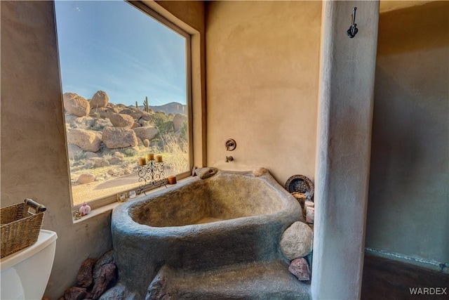 full bathroom featuring toilet and a bath