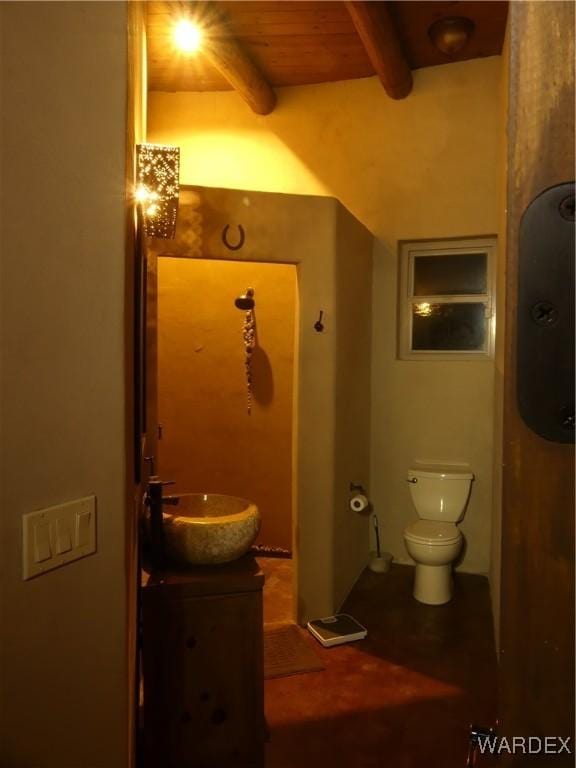 bathroom with vanity, beamed ceiling, and toilet