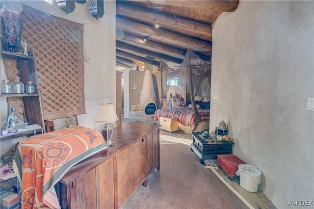 bedroom with beamed ceiling, carpet flooring, and wooden ceiling