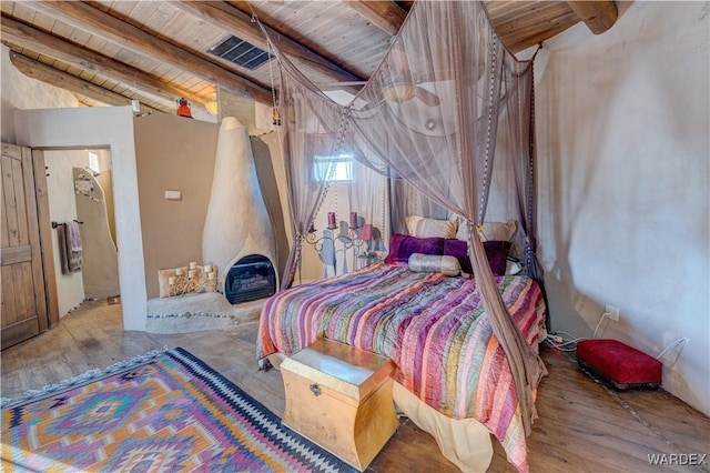 bedroom featuring visible vents, wood ceiling, lofted ceiling with beams, and wood finished floors