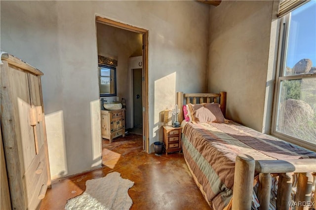 bedroom featuring multiple windows and concrete floors