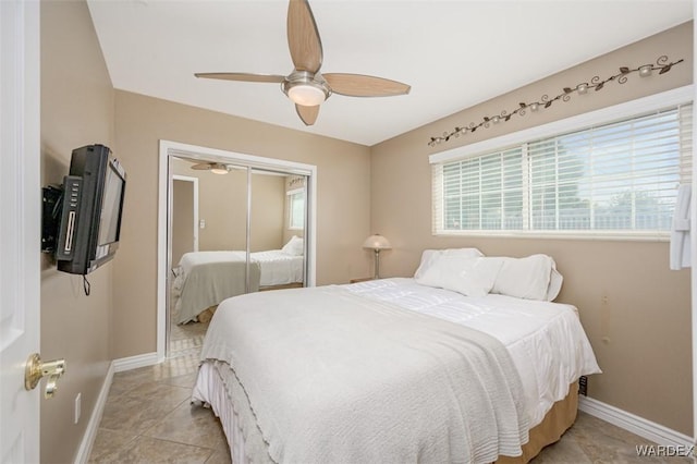 bedroom featuring a closet, light tile patterned flooring, ceiling fan, and baseboards