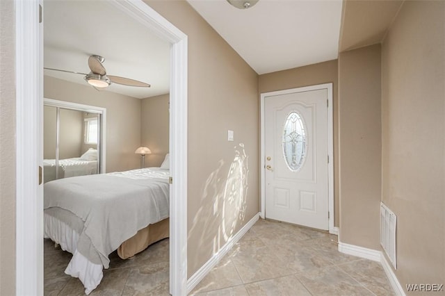 foyer featuring ceiling fan, light tile patterned floors, visible vents, and baseboards