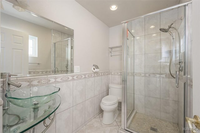 full bathroom featuring a stall shower, toilet, and tile patterned floors