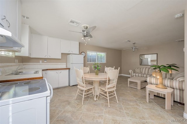 kitchen with light countertops, white appliances, white cabinets, and a sink