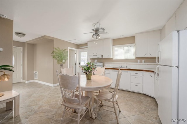 dining area featuring light tile patterned floors, visible vents, a ceiling fan, and baseboards