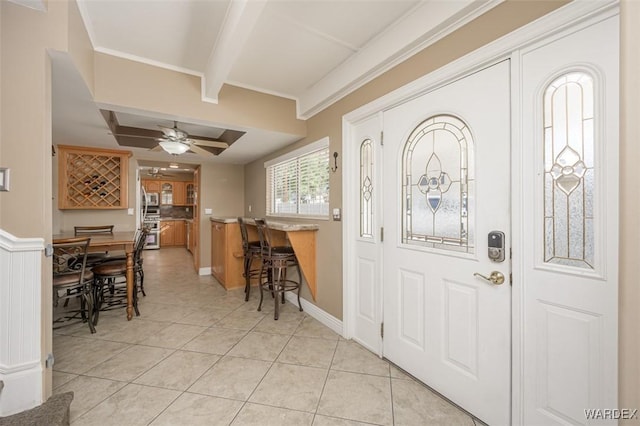 foyer featuring light tile patterned floors, a ceiling fan, beam ceiling, and crown molding