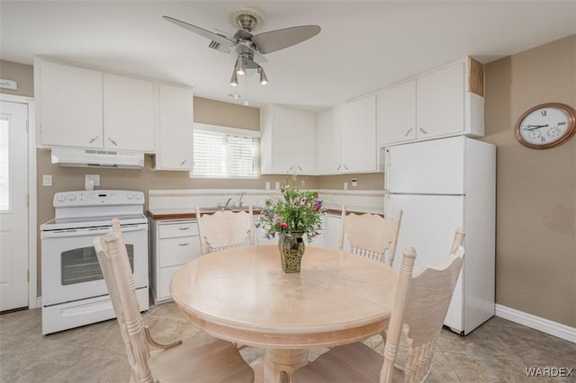 kitchen with light countertops, white appliances, white cabinetry, and under cabinet range hood