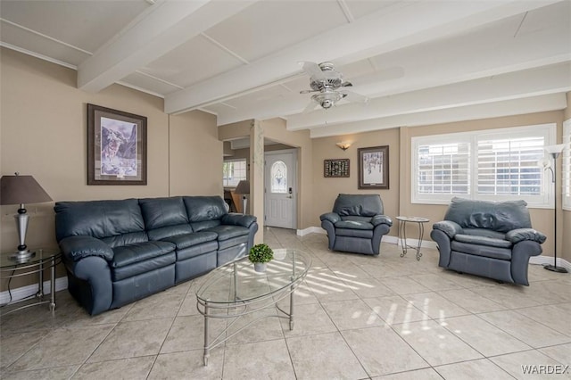 living area featuring ceiling fan, light tile patterned flooring, beam ceiling, and baseboards