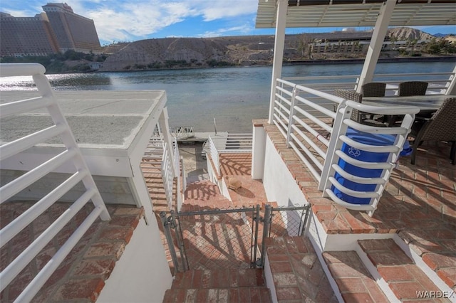 view of dock with a water view and fence