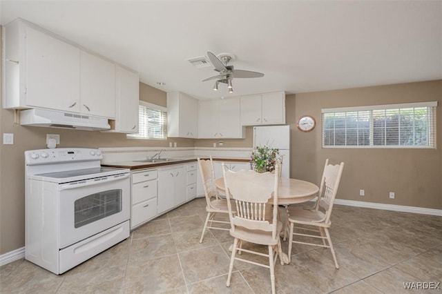 kitchen featuring white cabinetry, a sink, white appliances, under cabinet range hood, and baseboards