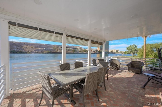 view of patio / terrace with a water view and outdoor dining space