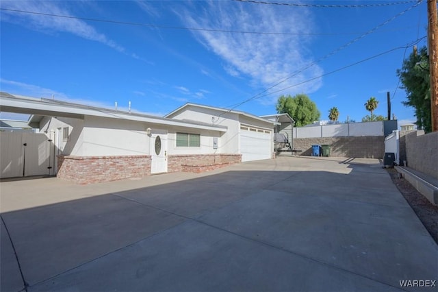 exterior space with a garage, concrete driveway, fence, and stucco siding