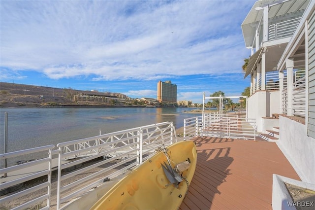 dock area with a water view and a balcony